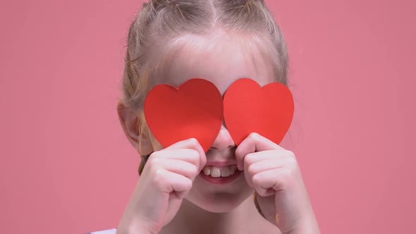 Smiling Girl Closing Eyes With Paper Hearts, Isolated on Pink Background, Fun