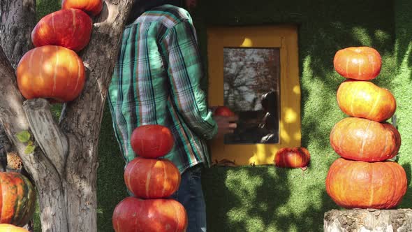 Man decorates house with pumpkins