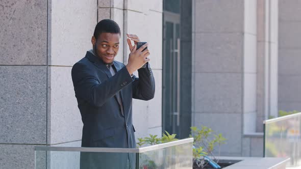 Happy Young African Black Office Worker Standing on Balcony Resting at Workplace Holding Phone