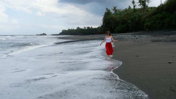 Young Woman Running on the Black Sand Beach