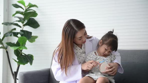 dentist, teaching how to brush in a hygienic way for a 3-year-old girl