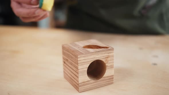 Close Up of Craftsman Hands Sanding the Surface of Handmade Wooden Box with Abrasive Paper Man