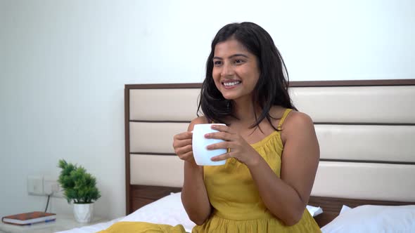 Happy Indian woman drinking tea
