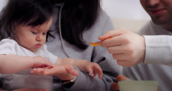 Young Parents Give Healthy Food to Baby Baby's First Food