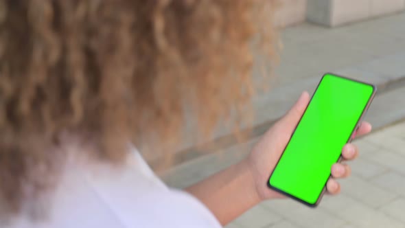 African Woman Holding Smartphone with Green Chroma Screen