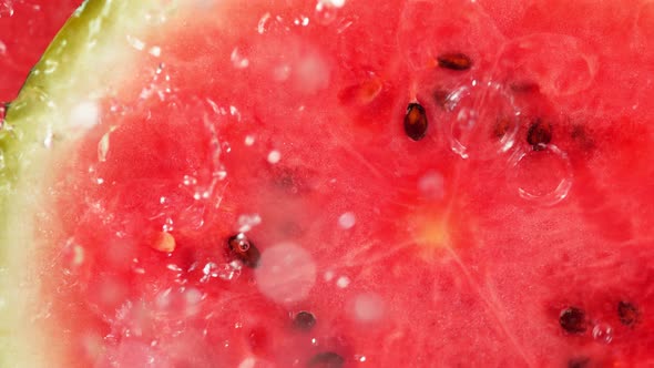 Super Slow Motion Macro Shot of Falling and Splashing Water Drops on Fresh Watermelon at 1000Fps.