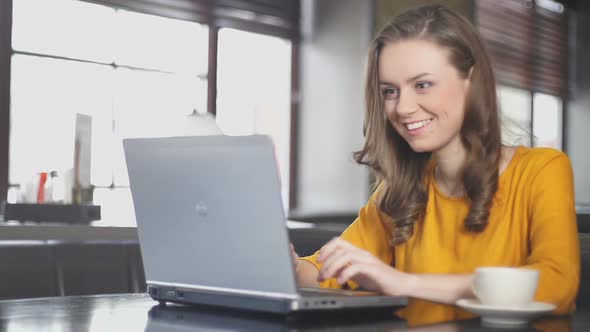 Excited Woman Using Laptop in Cafe, Winning Online Lottery, Dance of Victory