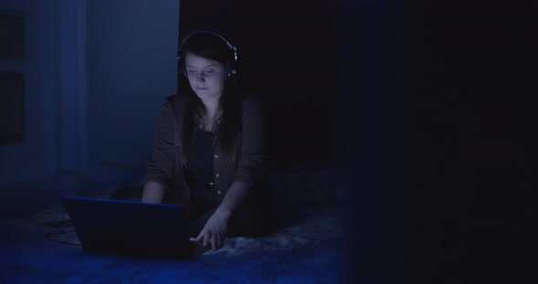 Woman with headphones in the bedroom