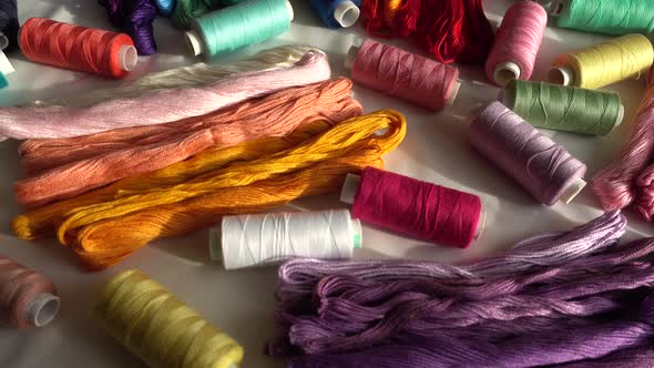 A top view of colorful mouline threads and multicolored spools isolated on a white background.