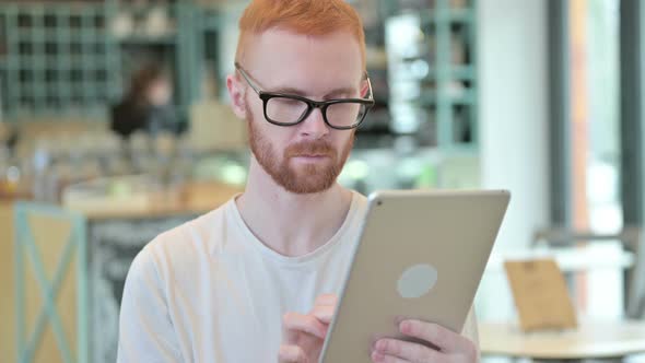 Portrait of Professional Redhead Man Using Digital Tablet 