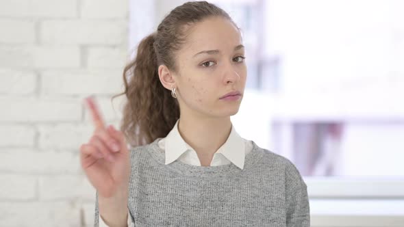 Portrait of Beautiful Young Latin Woman Saying No By Finger Gesture