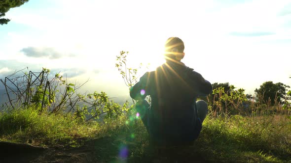 Man Hermit Meeting Up Sun Rise on the Edge of Mountains. Doing Meditation in Sun Light. Taking Off