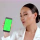 Beautiful Asian businesswoman showing smartphone with green screen - VideoHive Item for Sale