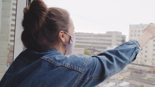 Young Woman in Face Mask Screaming Out Window