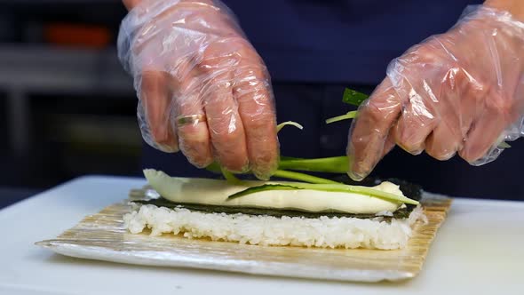 Hands cooking sushi with rice. Close up of chef hands preparing japanese food