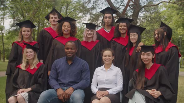 Happy Multiethnic Graduates and Academic Staff Posing for Picture Together