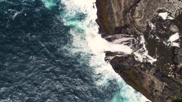 Aerial view of water encountering agitated Atlantic ocean, Faroe island.