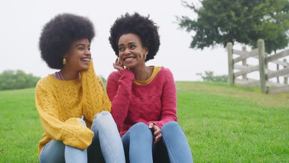 Two mixed race women laughing in park