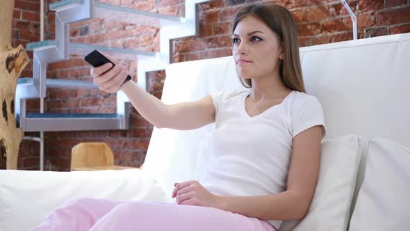 Woman Watching TV, Changing Channels with Remote Control