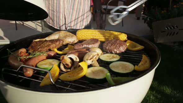 Closing Kettle Barbecue Grill in Garden