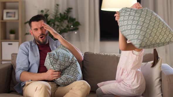 Father and Daughter Having Pillow Fight at Home