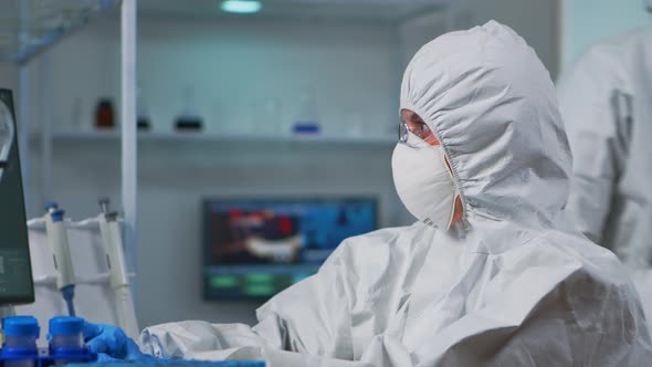 Close Up of Scientist in Protection Suit Typing on Pc