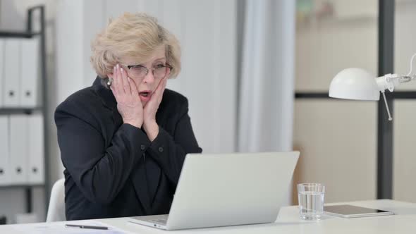 Old Businesswoman Reacting to Failure While Using Laptop at Work