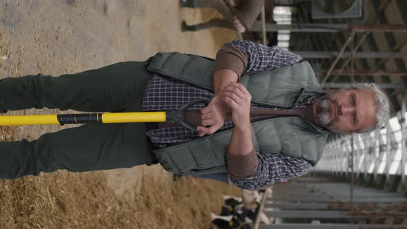 Vertical Portrait of Middle-Aged Man with Shovel at Farm