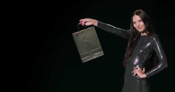 A Happy Shopper on Black Friday Holding Up a Shopping Bag Sale Young Smiling Woman Showing Shopping