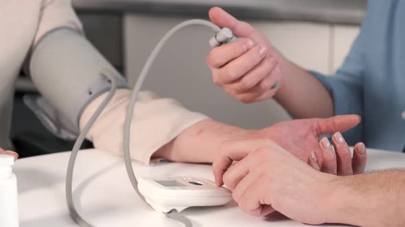 Couple Helping Disabled Mother Measure Blood Pressure