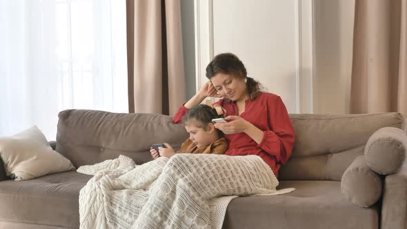 Mom and Daughter Spend Time at Home with Their Phones in Their Hands, Make Online Purchases and Chat