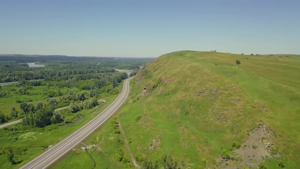Aerial: Flying Over the Highway Among the Mountains
