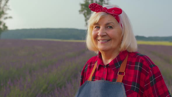 Portrait of Senior Farmer Worker Grandmother Woman in Organic Field Growing Purple Lavender Flowers