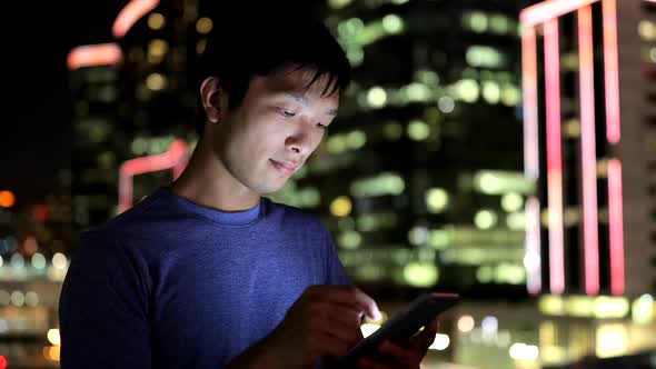 Asian man use of mobile phone at night 