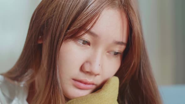 Close Up Unhappy Lonely Depressed Young Asian Woman At Home, She Is Sitting On The Couch