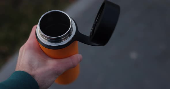 POV Male Hand Holding Thermos with Hot Tea in It