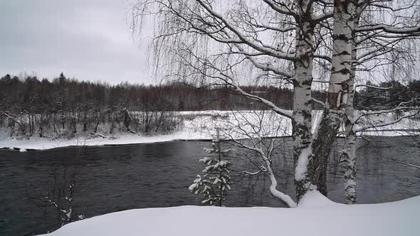 Panorama of river that flows in snowy winter landscape