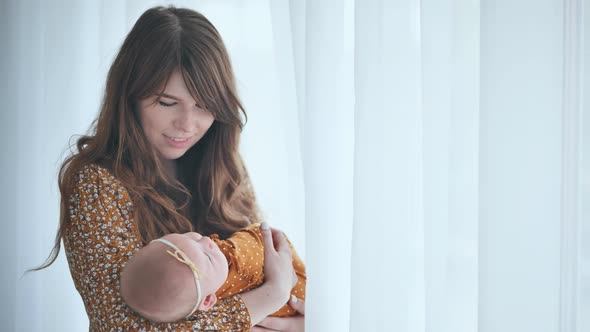 A Loving Mother and Child at the Window with Curtains