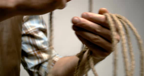 Close up of a cowboy winding the rope, gray background, 4k