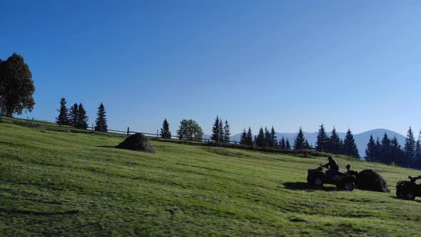 Three Men Riding on Atv Bikes on Green Hill