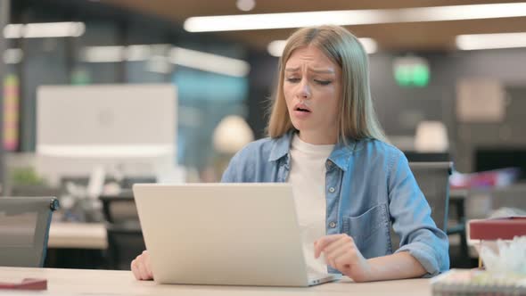 Young Woman Reacting to Loss While Using Laptop in Office