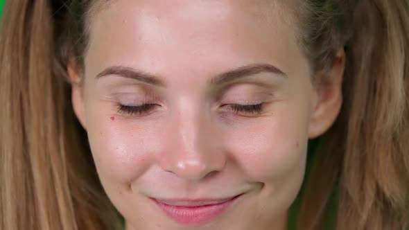 Portrait of a Beautiful Caucasian Female Blonde Young Woman Looks Into the Camera and Smiles Closeup