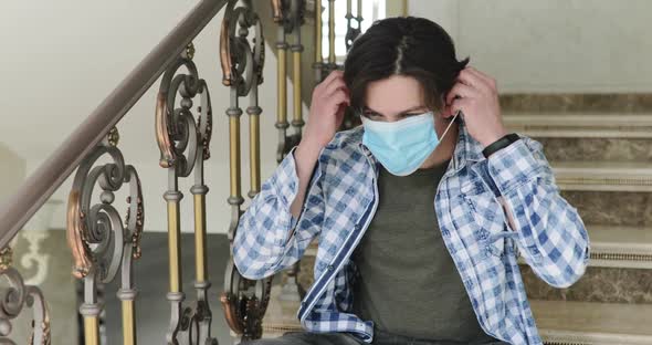 Sad Man Sitting on Stairs Wearing Mask and Thinking Lonely on Selfisolation