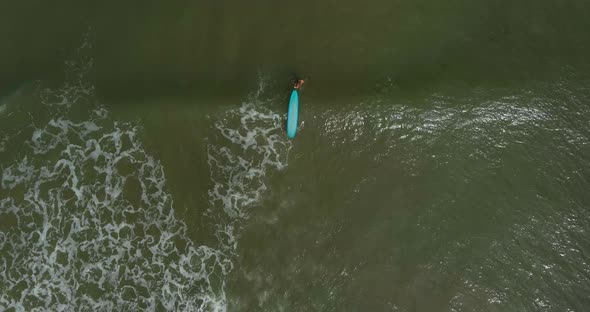 Birds eye view of female surfer in the Gulf of Mexico off the coast of Lake Jackson in Texas
