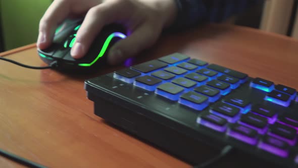 Young Gamer Plays a Video Game Uses Gaming Illuminated Keyboard
