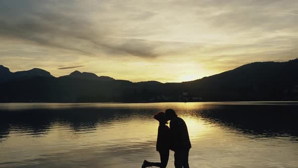 Silhouette of Kissing Couple Against Sunset at Mountain Top