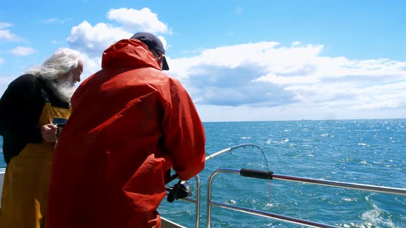 Two fishermen fishing from the boat