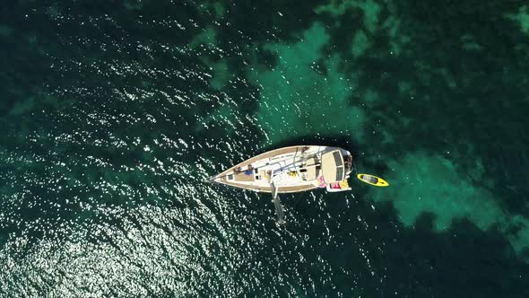 Aerial view above sailboat swinging on agitated waters in the coast of Greece.