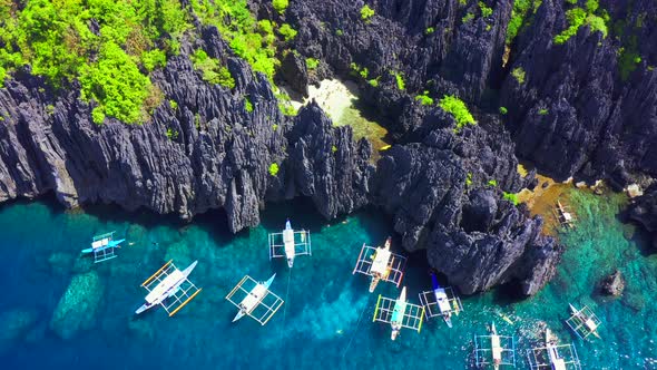 Aerial Drone View of Swimmers Inside a Tiny Hidden Tropical Lagoon Surrounded By Cliffs - Secret