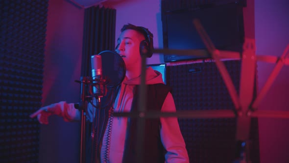 A Man Rapping Through the Pop-filter in the Microphone - Recording His Track in the Studio - Music